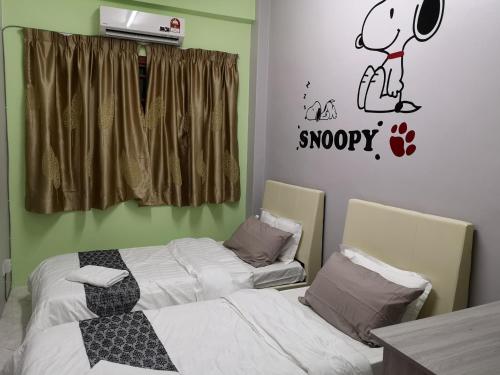 a bedroom with two beds and a snoopy sticker on the wall at Kelly Cozy cottage in Kampar