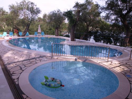 a pool at a resort with a ball in the water at Saint Nicholas Beach Resort in Dassia