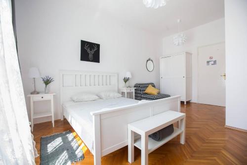 Dormitorio blanco con cama blanca y mesa en Oberiter Apartments - in the heart of Zagreb en Zagreb