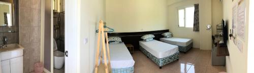 a small room with two beds and a sink at Fire Island Guest House in Green Island