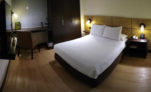 a bedroom with a large white bed and a desk at Scala 68 in Bogotá
