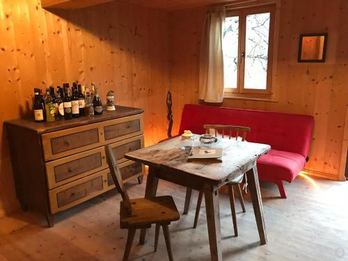 a living room with a table and a red couch at Knottn Hüttl, St. Pankraz/Ulten, Nähe Meran in San Pancrazio dʼUltimo