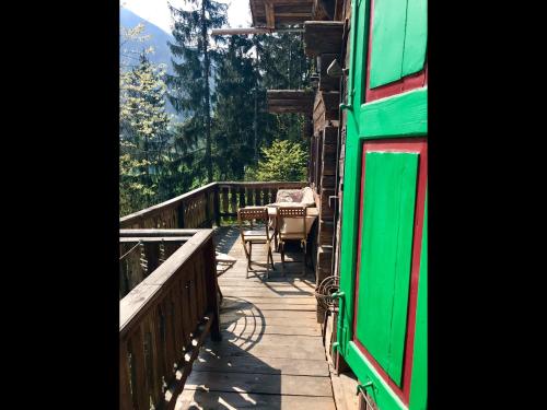 a wooden deck with a table and chairs on it at Knottn Hüttl, St. Pankraz/Ulten, Nähe Meran in San Pancrazio dʼUltimo