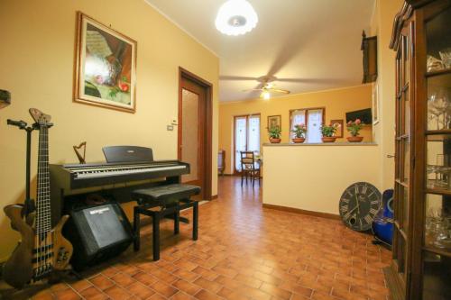 a living room with a piano and a guitar at Spighe Paglia e Girasole in Candia Canavese