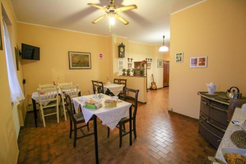 a dining room with tables and chairs and a kitchen at Spighe Paglia e Girasole in Candia Canavese
