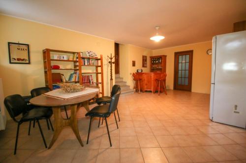 a kitchen with a table and chairs and a refrigerator at Spighe Paglia e Girasole in Candia Canavese