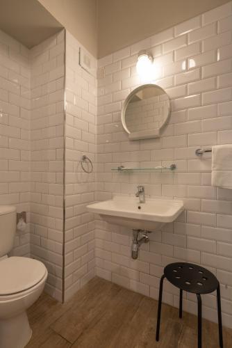 a white bathroom with a sink and a toilet at Chapter 5 Hotel in Taʼ Xbiex