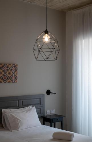 a bedroom with a bed and a light fixture at Chapter 5 Hotel in Taʼ Xbiex