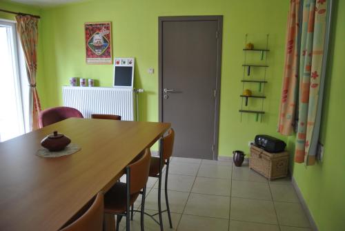 a dining room with green walls and a table and chairs at B&B La Place Verte in Surice