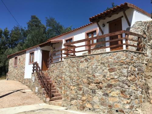 a house with a stone wall and a wooden balcony at Casas no Terreiro in Penacova
