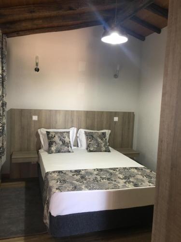 a bedroom with a large bed in a room at Casas no Terreiro in Penacova