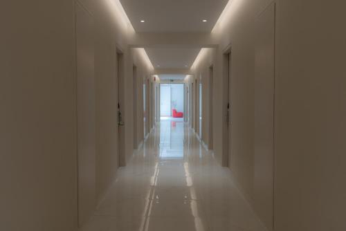 a hallway with white walls and a long hallway with lights at Elea Beach Hotel in Dassia