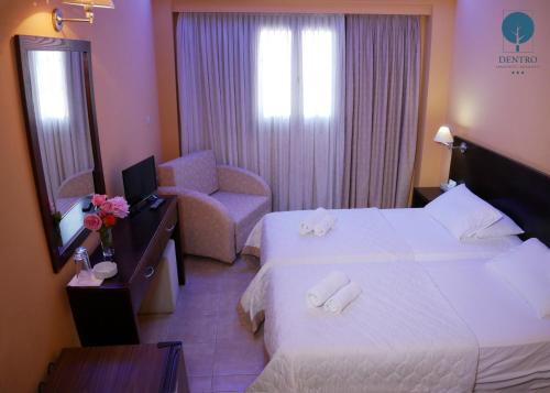um quarto de hotel com duas camas e uma cadeira em Grand Hotel Dentro em Konitsa