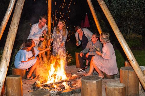 a group of people sitting around a fire at Ferienappartements Landhof in Ellmau