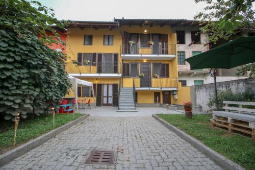 a yellow apartment building with a cobblestone driveway at Spighe Paglia e Girasole in Candia Canavese