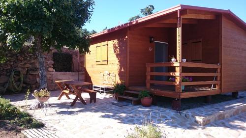 a small wooden cabin with a table and a bench at Casa DiMaria in Trancoso