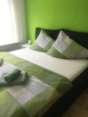 a bed with green and white sheets and pillows at Karls Ferienwohnung in Teufenbach