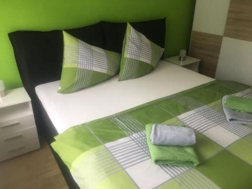a bedroom with a bed with green and white pillows at Karls Ferienwohnung in Teufenbach