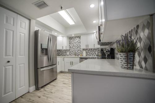 a kitchen with white cabinets and a stainless steel refrigerator at Townhouse at San Remo in Clearwater Beach