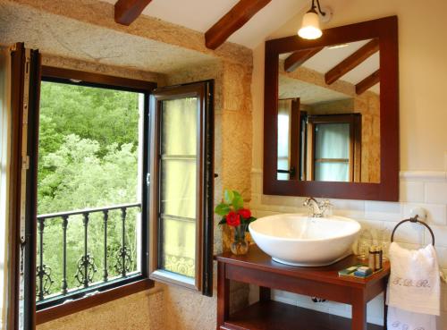 a bathroom with a sink and a large window at Torre do Rio in Caldas de Reis
