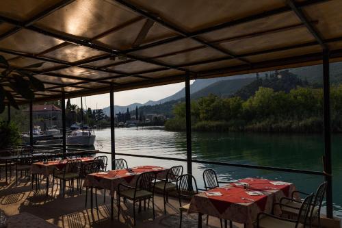 a group of tables and chairs with a view of a river at Hotel Vimbula - Komolac in Mokošica