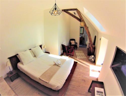 a bedroom with a bed and a tv in it at La Closeraie in Noyers-sur-Cher