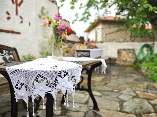 a table with a white lace table cloth on it at Guesthouse Xenios Zeus in Stavroupoli