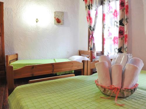 a small room with two beds and a green bedspread at Guesthouse Xenios Zeus in Stavroupoli