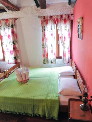 a bedroom with two beds in a room with pink walls at Guesthouse Xenios Zeus in Stavroupoli