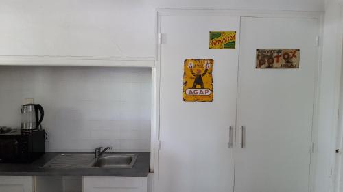 una cocina con 2 armarios blancos y un fregadero en Leucateloc, en Leucate-Plage