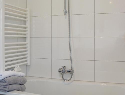 a bathroom with a shower with towels on a tub at Ferienwohnung Teltow 2 in Teltow