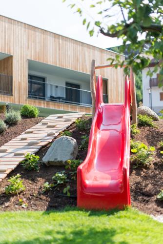 a red slide in a garden in front of a building at Moar am Ort in Schenna