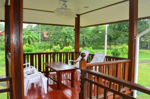 a screened in porch with a table and chairs at Bang Hon Homestay in Ko Yao Noi