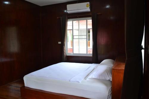 a bedroom with a white bed and a window at Bang Hon Homestay in Ko Yao Noi