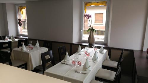 a dining room with two tables and a vase with flowers at Maison de Laveline in Laveline