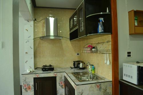 a small kitchen with a sink and a microwave at Bang Hon Homestay in Ko Yao Noi