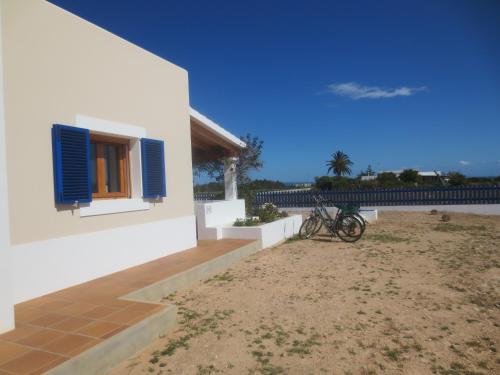a house with a blue window on the side of it at Casa Rural Ideal para Parejas - Formentera in Sant Francesc Xavier