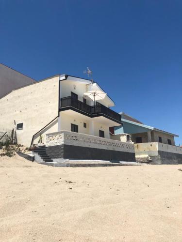 a building sitting on top of a sandy beach at Paradiso fronte Mare in Agnone Bagni