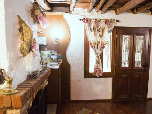 a room with a fireplace and a door with a window at Guesthouse Xenios Zeus in Stavroupoli