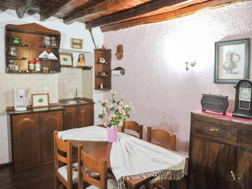 a kitchen with a table with a vase of flowers on it at Guesthouse Xenios Zeus in Stavroupoli