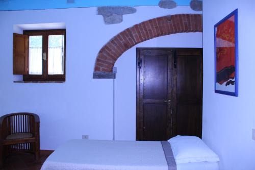 a bedroom with a bed and a door and a chair at Il Casolare in Penna