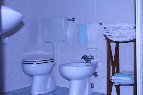 a white bathroom with a toilet and a sink at Il Casolare in Penna