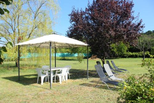 a table and chairs under an umbrella in a field at Il Casolare in Penna