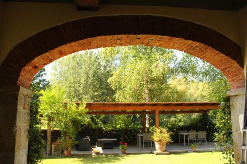 a brick archway with a picnic table and trees at Il Casolare in Penna