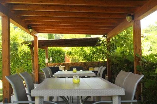 a table and chairs under a wooden pergola at Il Casolare in Penna