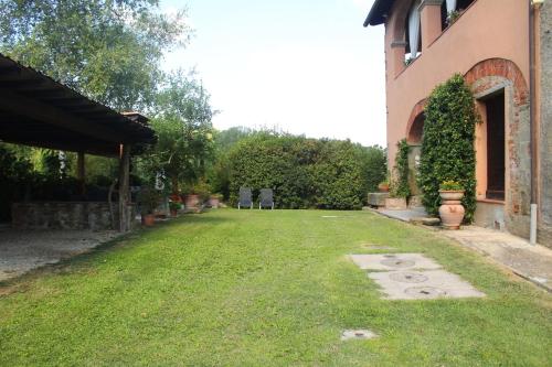 a yard next to a building with a grassy yard at Il Casolare in Penna