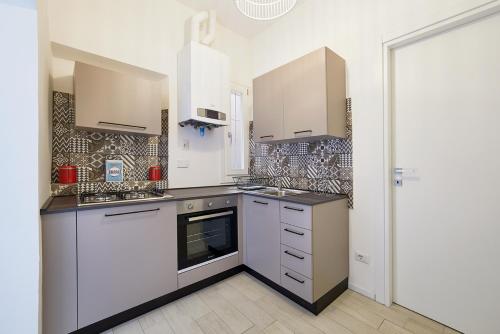 a kitchen with white cabinets and a stove top oven at Burò Bed & Relax in Parma
