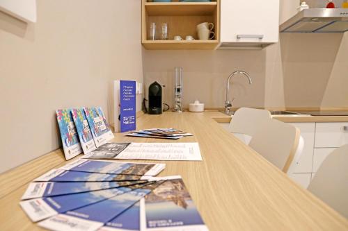 a kitchen counter with a wooden table with papers on it at APP9 - rooms and apartments in Bergamo