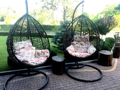 two swings with beds and pillows on a patio at Victoriya's House in Hisarya