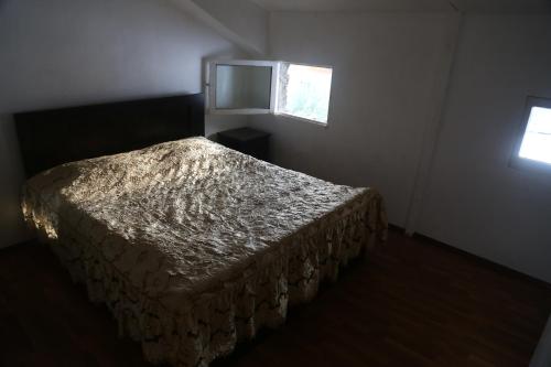 a bed in a bedroom with a window at N&N Guest House in Mestia